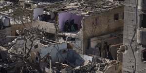 Palestinians look at the destruction after an Israeli strike on residential buildings and a mosque in Rafah,Gaza Strip.