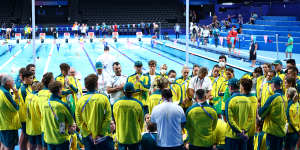 The Australian swim team huddle on pool deck in Paris.
