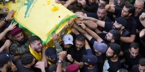 Hezbollah members carry the coffin of their comrade who was killed on Wednesday when a handheld device exploded,during a funeral procession in the southern suburbs of Beirut.