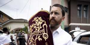 Chaim Klein carries a Torah scroll from Adass Israel synagogue on Friday afternoon.