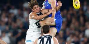 Kallan Dawson of the Kangaroos and Charlie Curnow of the Blues compete for the ball.