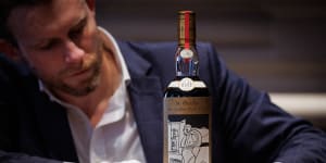 Jonny Fowle,Sotheby’s global head of spirits,unveils a bottle of The Macallan 1926,the world’s most expensive whisky.