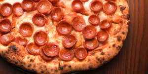 Pepperoni pizza is assembled with precision.