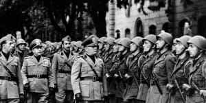 Italian Premier Benito Mussolini,right,and members of his staff review troops of the newly formed Fascist battalions on the outskirts of Rome,Italy on October 19,1941.
