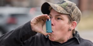 Moo Blake takes a dose of an inhaler in East Palestine,Ohio. Blake was diagnosed with bronchitis due to chemical fumes after the spill.