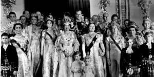 Queen Elizabeth II in her coronation robes with her sister Margaret (left of her),husband and mother (right),children Charles and Anne,and other family members in 1953.