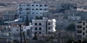 An Islamic State (IS) flag (top) flutters on the roof of a building in the Syrian town of Kobane.