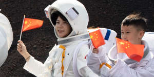 Patriotic tourists dress up as astronauts to watch the rocket launch in Hainan. 