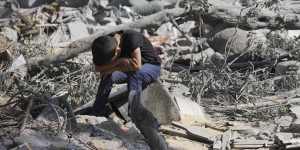 A Palestinian boy sits on the rubble of the building destroyed in an Israeli airstrike in Bureij refugee camp Gaza Strip.