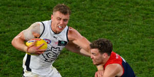 Patrick Cripps attempts to fend off Jack Viney.