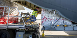 Air Force Air Movement Operators from No. 23 Squadron load humanitarian supplies onto a C-130J Hercules aircraft bound for Tonga,at RAAF Base Amberley,Queensland,as part of Operation Tonga Assist 2022. 