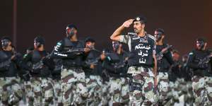 Saudi security forces parade on the eve of the Haj. The writing on the officer's chest reads"serving you is an honour for us".