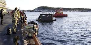 The car is retrieved from the water in front of the floating sauna after driving out into the Oslofjord,in Oslo.