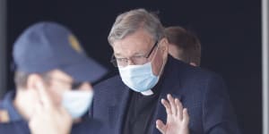 Cardinal George Pell waves as he arrives in Rome following a flight from Australia.