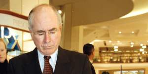 Then-Prime Minister John Howard examines a pamphlet on how to shop with the GST on July 1,2000.