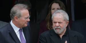 Former Brazilian president Luiz Inacio Lula da Silva,right,and Senate President Renan Calheiros,chat at the end of a breakfast with senators of the government's allied base,in Brasilia,on Wednesday,before charges were laid.
