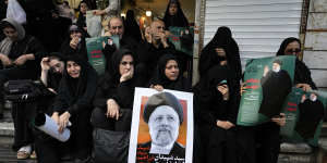 People hold up posters of Iranian President Ebrahim Raisi during a mourning ceremony for him in downtown Tehran,Iran.