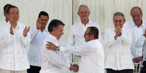 Colombian President Juan Manuel Santos,front left,and the top FARC Timochenko,shake hands after signing the peace agreement. Behind,from left,are UN's Ban Ki-moon,Mexican President Enrique Pena Nieto,Peruvian President Pedro Pablo Kuczynski,Cuban President Raul Castro,and Spain's former King Juan Carlos.