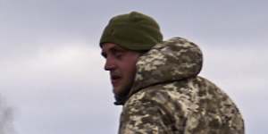 Ukrainian soldiers pass by a volunteer bus burning after a Russian drone hit it near Bakhmut,Donetsk region.