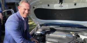 Queensland Renewables and Hydrogen Minister Mick de Brenni checks under the bonnet of a Hyundai NEXO.