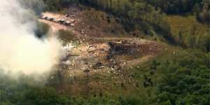 Smoke fills the air as debris covers the ground and vehicles after a powerful blast ripped through a military explosives manufacturing plant in Hickman County,Tennessee.