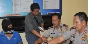 Captain Yohanis Humiang (left) looks on as head of the people smuggling division of Nusa Tenggara Timur,Ibrahim,Rote police chief Hidayat and East Nusa Tenggara Timur police chief General Endang Sunjaya count money in June.