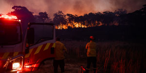 Rural Fire Service volunteers watch a bushfire which started near Oxford Falls burn slowly through bushland toward Cromer in Sydney’s northern beaches.