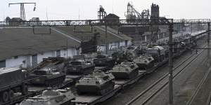 Russian armored vehicles are loaded onto railway platforms at a railway station in region not far from Russia-Ukraine border on February 23.