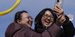 Women take a selfie with a giant dragon lantern in Beijing.