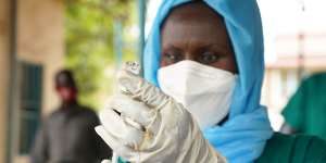 A healthcare worker prepares to administer a vaccine in South Sudan through the World Health Organisation’s COVAX scheme.