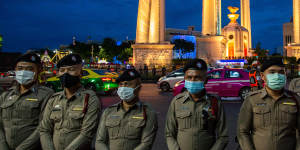 Police monitor an anti-government protest in Bangkok on Monday.