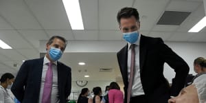 NSW Premier Chris Minns (right) and Health Minister Ryan Park (left) talk with a patient in the endoscopy ward at Liverpool Hospital.