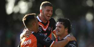 Luke Brooks,Adam Doueihi and James Roberts celebrate a Wests Tigers try last year.