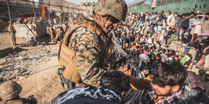 A US Marine assists during an evacuation at Hamid Karzai International Airport in Kabul. 