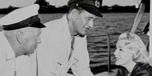Director John Farrow (left) with John Wayne and Lana Turner on the set of The Sea Chase. 