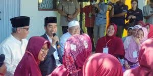 Joko Widodo addresses residents in Serang,Banten,accompanied by the chairman of the Financial Services Authority,Wimboh Santoso,and the head of Indonesian Ulema Council Ma'ruf Amin. 