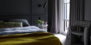 In the main bedroom,a custom-built panelled wall acts as both bedhead and disguise for the wardrobe behind. The wall colour is Dulux “Champignon” in half strength.
