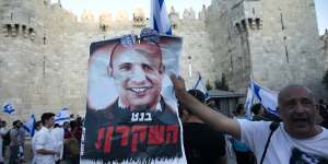 A marcher holds a aposter with a photo of new Israeli Prime Minister Naftali Bennett with the word “liar” in Hebrew,near the Damascus Gate on Tuesday.