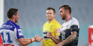 Bulldogs captain Josh Jackson goes to shake hands with Kyle Feldt but the Cowboys winger opts for a safer approach.