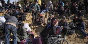 Displaced Palestinians wait near a roadblock after being stopped from returning to northern Gaza.