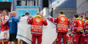 Medics and the Danish soccer team surround Eriksen on the pitch after he suffered a medical emergency.