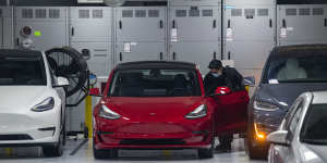 A worker wearing a protective mask cleans a Tesla Inc. vehicle at a store in San Francisco on Tuesday.