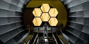 NASA engineer Ernie Wright looks on as the first flight-ready mirror segments are prepped to begin final cryogenic testing at NASA’s Marshall Space Flight Centre this year in prepartion for the James Webb Space Telescope’s launch,now scheduled for Christmas Day. 