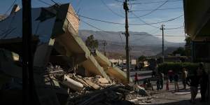 People walk next to a destroyed house after an earthquake in the city of Darbandikhan,northern Iraq,on Monday.