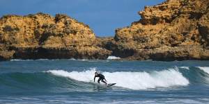 A surfer takes to the waves at Torquay. 