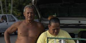 A couple sells bags of freshly caught tuna by the side of the road in Teahupo’o.