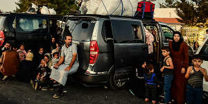 Lebanese families escaping airstrikes at a border crossing into Syria.