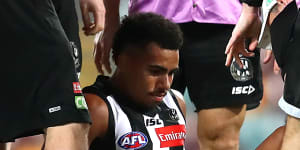 Isaac Quaynor is helped from the field after suffering a serious cut to his leg.