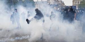 A man kicks a tear gas canister during a march against police brutality and racism in Paris on Saturday,June 13.