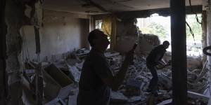 Ukrainians inspect their office damaged in a drone attack on Kyiv on Sunday.